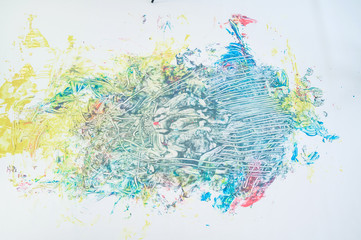 Top view of a naked woman in a spray of paint. A girl without clothes lies on a white floor in colored spots. Original body painting.