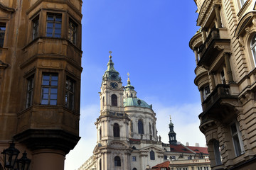 Fototapeta na wymiar view to St. Nicholas Church, also called Kostel Svateho Mikulase, in Prague, Czech Republic, with its dome seen from Karmelitska street, in the Mala Strana District, of the old town