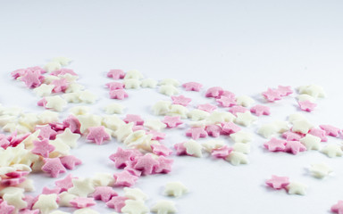 Sugar star cake decorations pink and white, little decors for muffins, gingerbread, cookies and all other baking. White background bright colours with copy space.