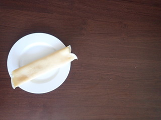   single rolled pancake on a white plate