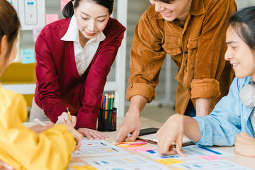 Asian businessmen and businesswomen meeting brainstorming ideas about creative web design planning...