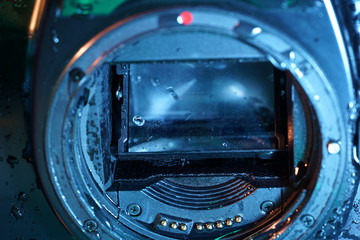 With digital photo cameras, the mirror and the housing with water cleaning