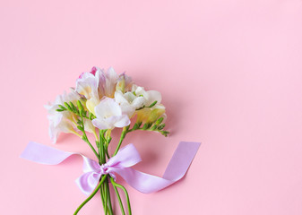 a bouquet of spring flowers lies on a pink background of a pastel shade, a festive minimalism,flat lay