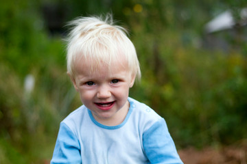 Portrait of cute funny blond baby outdoors on a summer day