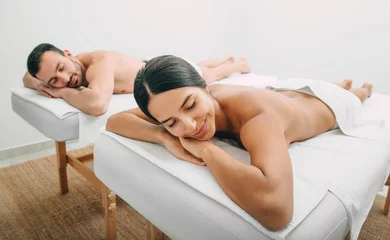 Wall murals Massage parlor Couple enjoys relaxing in the spa’s massage parlor. Honeymoon at the spa. Antistress relaxing honey massage, peeling