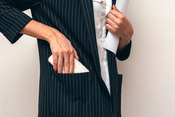 Business lady puts phone in jacket pocket.