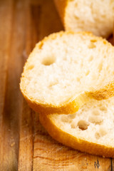 Freshly baked baguette bread on the rustic background. Selective focus. Shallow depth of field.