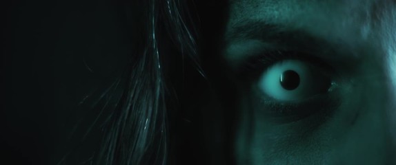 Terrifying creepy zombie woman, close up of white eye opening. Scary look.