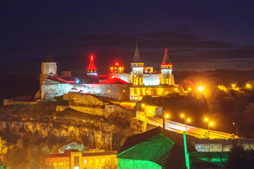 Fortress in Kamenetz-Podolsk at night in the light of lanterns