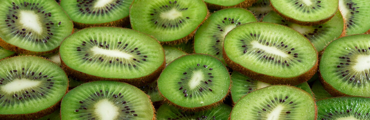 Slices of ripe kiwi. Background and texture. Panorama.