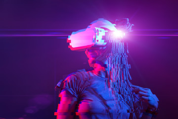 Fototapeta na wymiar Woman is using virtual reality headset. Neon light studio portrait. Image with glitch effect.