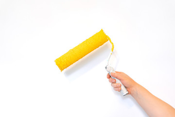 hand with a roller painted yellow isolated on a white background