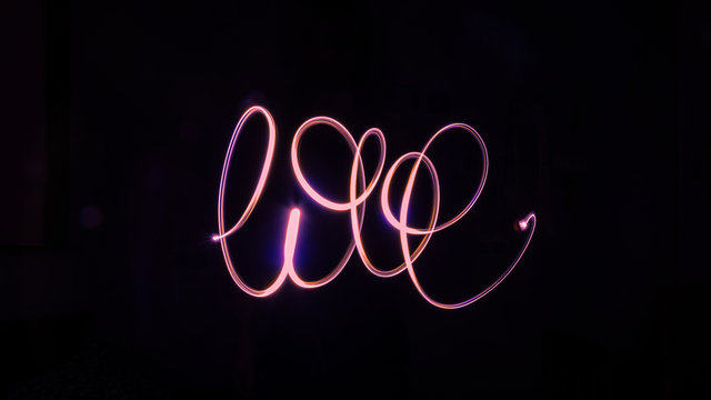 Isolated red light painting of the handwritten word 'love'