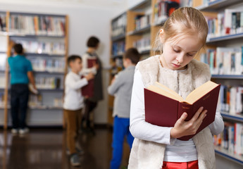 Preteen girl browsing textbook