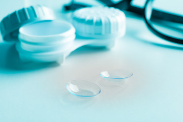Glasses, contact lenses and case on white background, close up