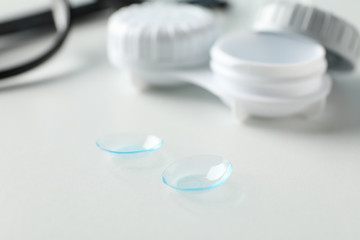 Glasses, contact lenses and case on white background, close up