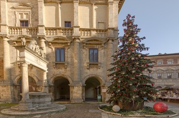 Montepulciano square with Christmas tree near the Grifi and Leoni well - obrazy, fototapety, plakaty