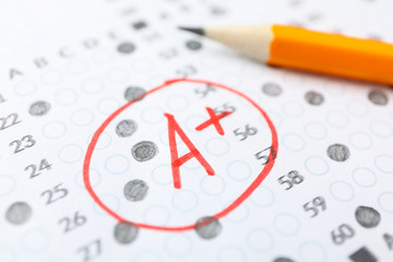 Test score sheet with answers, grade A+ and pencil, close up - obrazy, fototapety, plakaty