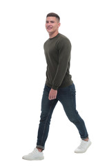 in full growth. a confident man in jeans walks forward .