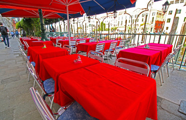 Empty Outdoor Restaurant Tables in Venice, Italy.  Unrecognizable Tourists.