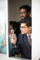 Corporate meetings between  young and energetic Indian Bengali bosses/officers/managers and secretary at window of the office building regarding buying a project land. Indian corporate lifestyle