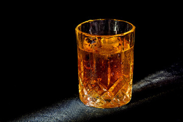 Glass with a drink on a black background