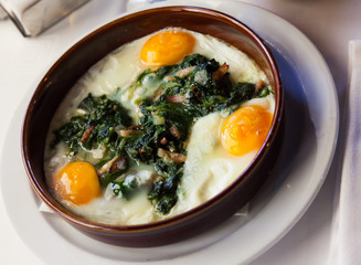 Fried eggs with spinach, raisins and ham, dish of Catalan cuisine
