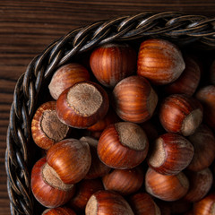 Lots of hazelnuts in shells in a wooden basket, close up.