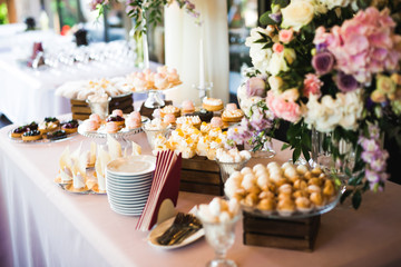 Delicious sweets on wedding candy buffet with desserts, cupcakes