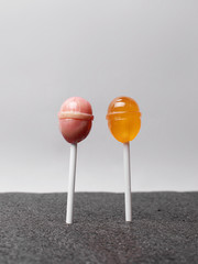  Pink and orange chupachups on a white background