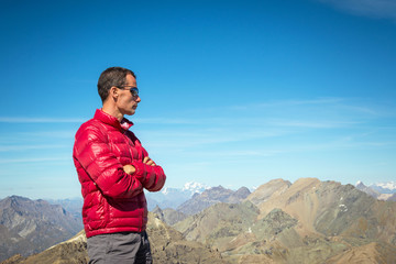 Man dressed winth mountain winter clothes looking at panorama. Italian Alps