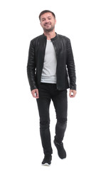 in full growth. casual young man walks forward .