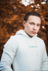 Herbstportrait von einem jungen Mann mit Kapuenpullover