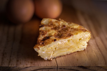 Homemade slice of spanish potato omelette accompanied with bread