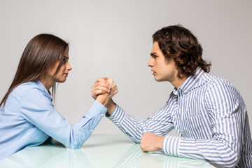 Husband and wife are fighting in their arms, arm wrestling between male and female. Family quarrel, showdown, division of property, divorce. The struggle between women and men.