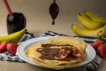 Delicious homemade crepes with strawberries, banana and chocolate