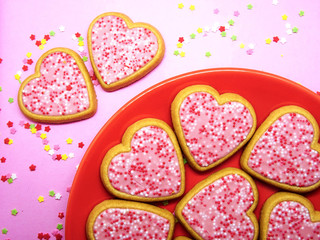 Obraz na płótnie Canvas Some sweet cookies with heart shape in a orange plate