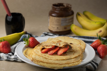 Delicious homemade crepes with strawberries, banana and chocolate