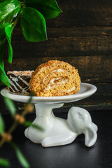 piece of cake on a stand biscuit roll (sweet honey dessert) menu concept. background. top view. copy space