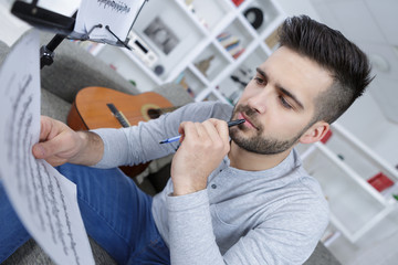 young man reading guitar partition