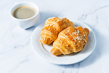 Fresh croissants with berries and cup of coffee