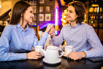 Happy young man and woman drinking tea in cafe