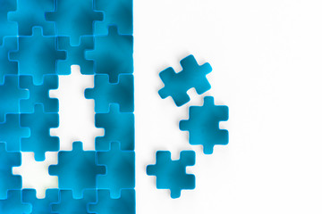 3d rendering of jigsaw puzzle concept. Shiny blue unfinished puzzles game mockup, connecting together on white background. Jigsaw pieces merging, design mock up. Big desktop toy template.  Copy space