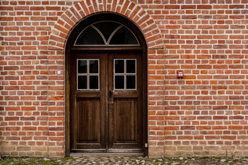 Brick wall with beautiful old wood doors.