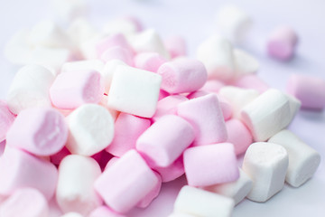 Obraz na płótnie Canvas Marshmallow pile for baking decorations in pink and white colours. Handfull of sweet fluffy and soft sponges. White background with copy text space.