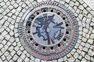 Fototapeta na wymiar Berlin sewer hatch with image of city landmarks