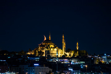 Fototapeta na wymiar The moon stands like a crescent moon over the Fatih Mosque at night