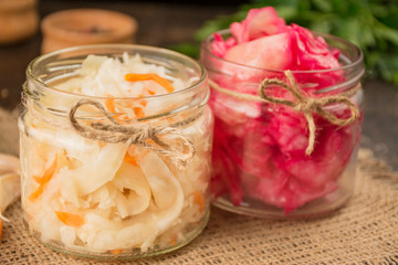 Sauerkraut with carrots and coleslaw with beets in a small jar. Homemade food. Sour food. Pickled vegetables. Featured products. Side view .