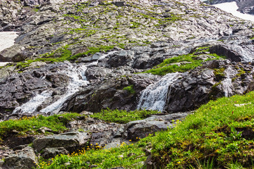 Fototapeta na wymiar fast mountain stream with a waterfall closeup