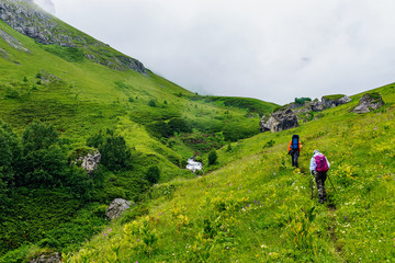 Obraz premium tourists with backpacks travel in the caucasus mountains